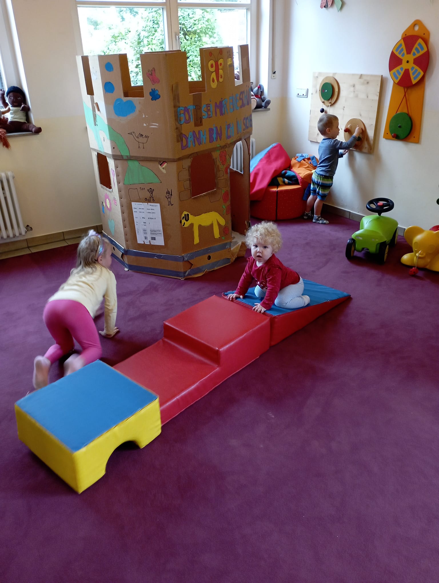 Kleinkinder in einem Raum mit vielen Spielmöglichkeiten.